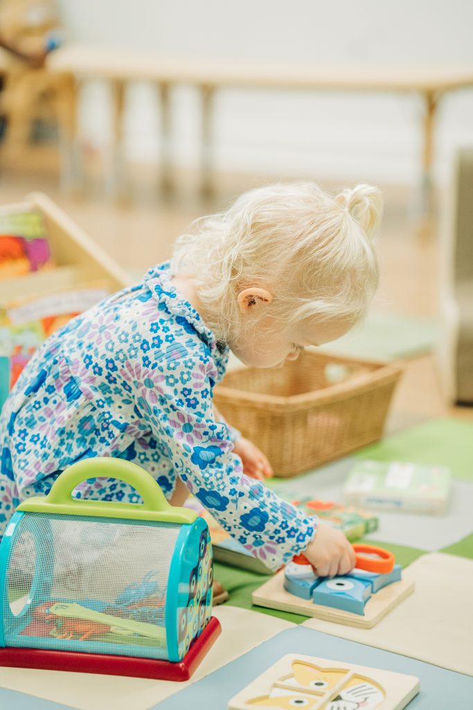 toddler at preschool with toys